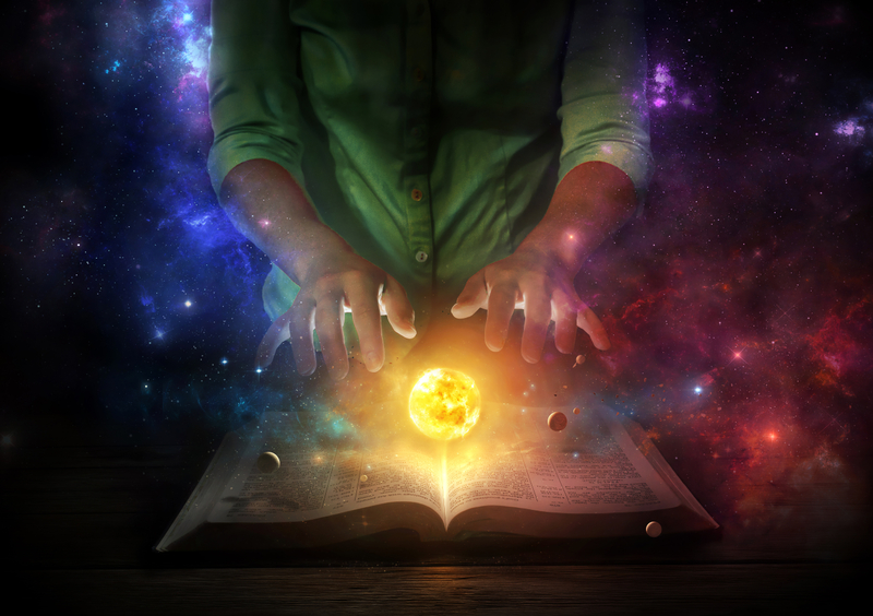 Two hands over the universe coming from a Bible.